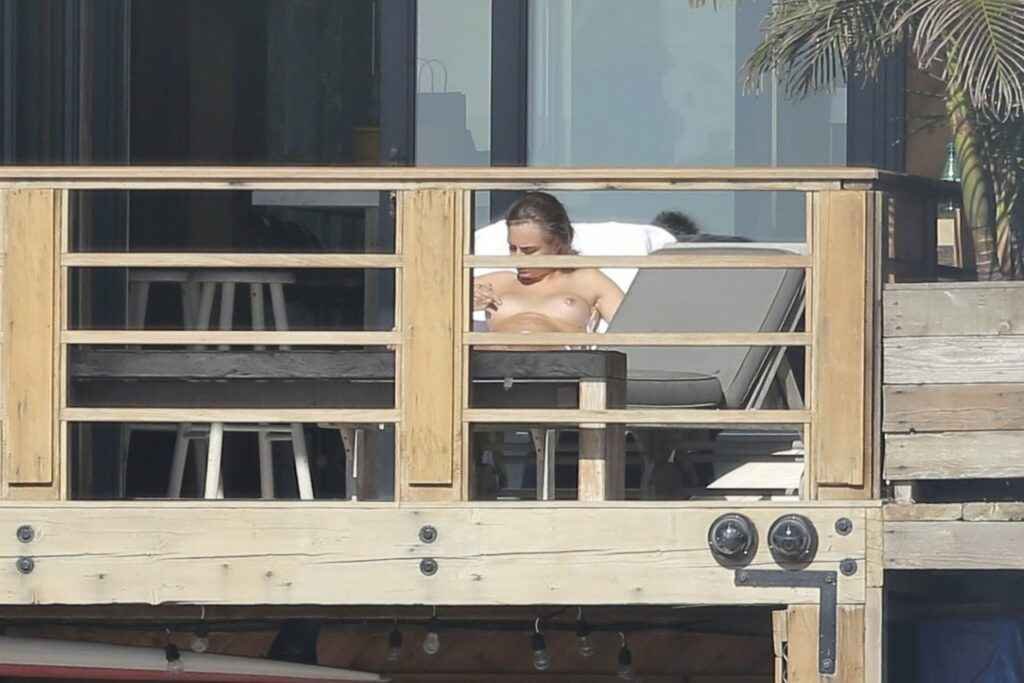 Cara Delevingne montre ses seins sur le balcon